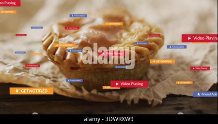Sitting golden-brown hand pie on parchment on dark wooden tabletop, with digital notifications Stock Photo