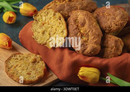 Fresh potato rolls in a basket with orange cloth, one cut open Stock Photo