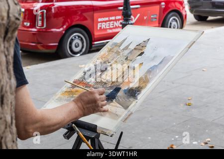 Street artist painting an urban city watercolor on an easel outdoors. London, UK, 10 August 2024 Stock Photo