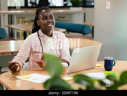 Female programmer typing code while calculating sum of array range at desk with laptop. Coding, workstation, office, minimalist, tech, focus, data Stock Photo