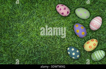 Colorful decorated Easter eggs arranged on vibrant green grass, showcasing various patterns and colors, ideal for spring celebrations and holiday Stock Photo