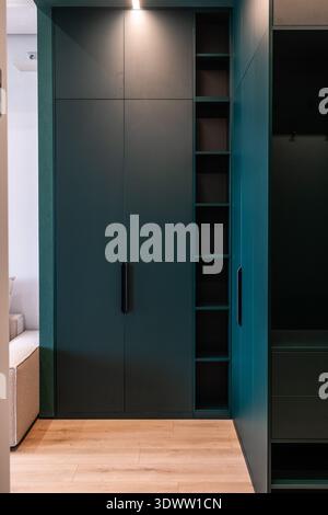 Matte teal wardrobe with built-in open shelves Stock Photo