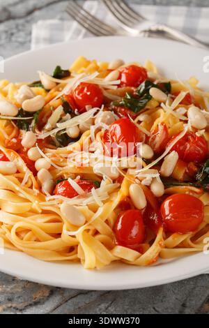 Tuscan White Bean Pasta closeup on the plate on the table. Vertical Stock Photo