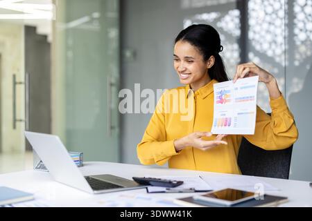 Confident businesswoman presenting data analytics on multiple computer ...