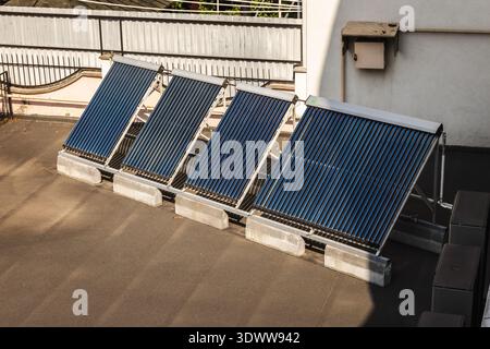 Solar thermal collectors installed on flat rooftop for renewable energy and water heating system Stock Photo