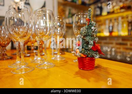 Empty wine glasses and a Christmas tree on a bar table Stock Photo