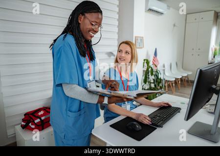 Healthcare professionals collaborating on medical records in hospital Stock Photo