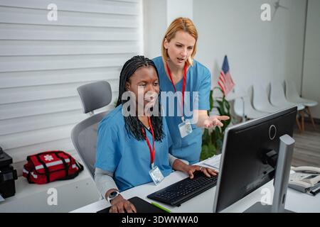 Diverse medical colleagues collaborating on computer in office Stock Photo