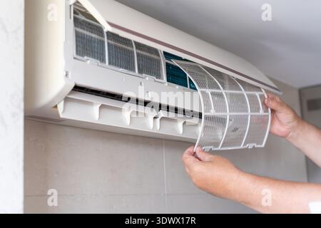 A male air conditioner technician or air conditioning installation. technician is about to repair air conditioning in homes and buildings. Stock Photo