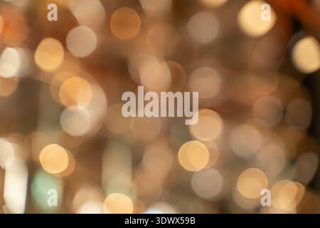 Abstract blurred background featuring luminous circles in warm shades, symbolizing celebration, romance, and festive mood. Golden bokeh effect with so Stock Photo