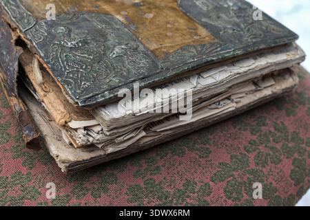 Buying antique books. Vintage books are stacked on a wooden table. Restoration of old books.An old torn book in need of restoration. Stock Photo