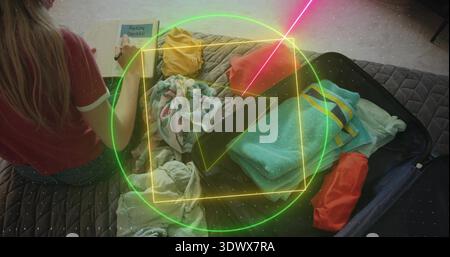 Packing traveler in red T-shirt and shorts marking checklist on bed with open suitcase, copy space Stock Photo