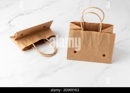 Empty brown craft paper bags with handles and holes for vegetables or fruits in supermarket. Small paper packaging for cherry tomatoes or grape standi Stock Photo