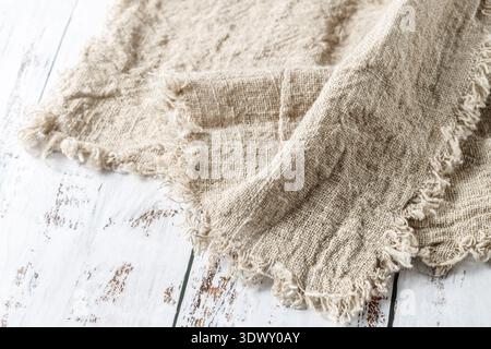 Crumpled natural linen kitchen serviette on vintage wooden table. Rustic background with copy space Stock Photo