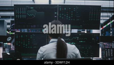 Professional Asian Woman in Business Attire Manages Investments in Futuristic Exchange Center. Concept of Innovative Digital Workspace and Big Data Visualization in Modern Financial Industry. Stock Photo