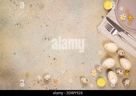 Festive easter table setting featuring cutlery, plate, and decorative elements like eggs and small flowers, creating a welcoming atmosphere for spring Stock Photo