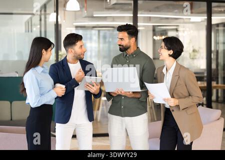 Multiethnic team members engaged in corporate briefing in coworking office Stock Photo