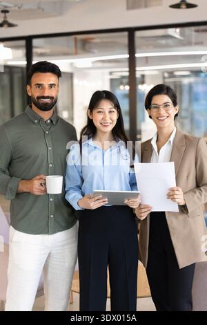 Professional team members standing in corporate office, portrait Stock Photo