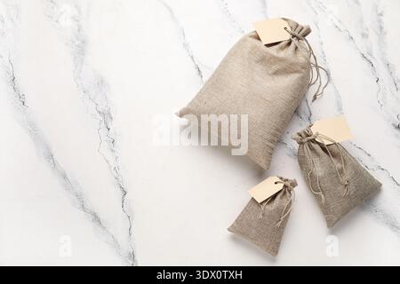 Full sacks with tags on grunge white background Stock Photo