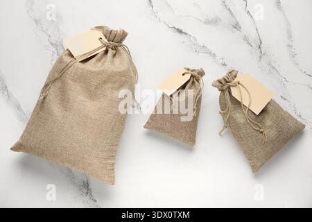 Full sacks with tags on grunge white background Stock Photo
