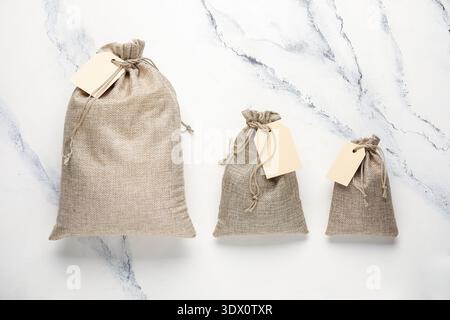 Full sacks with tags on grunge white background Stock Photo