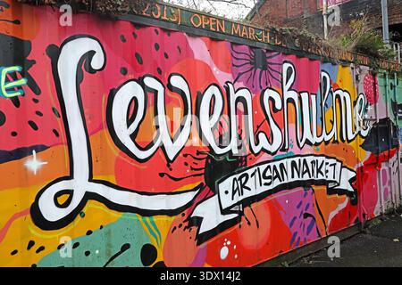 Colourful Levenshulme Artisan Market mural and opening information painted on a car park container off Stockport Road in Levenshulme, Manchester. Stock Photo