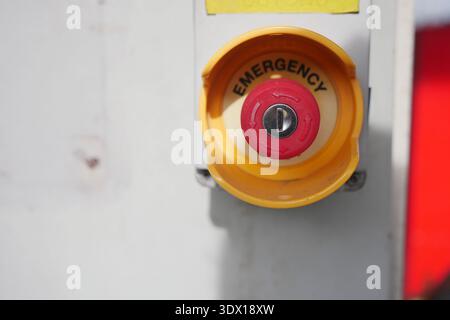 Emergency button on equipment in a workspace area Stock Photo