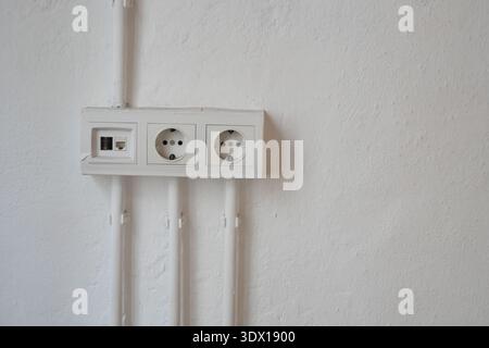 Electrical outlets are installed on a plain wall Stock Photo