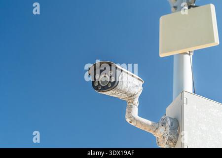 Security Camera on Pole Against Blue Sky. Video Surveillance System Outdoor. Modern Tech. Stock Photo