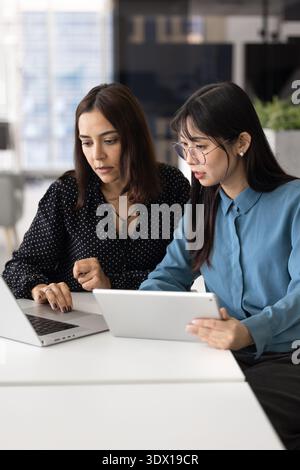 Focused divers young female professional coworkers watching online product content Stock Photo