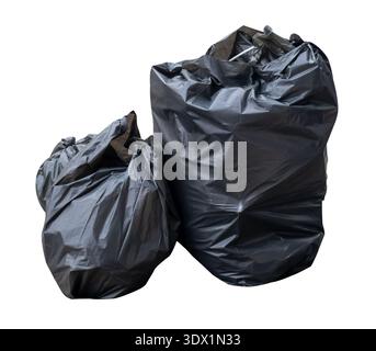 Garbage in black garbage bags in stack at garbage dump is isolated on white background with clipping path. Stock Photo