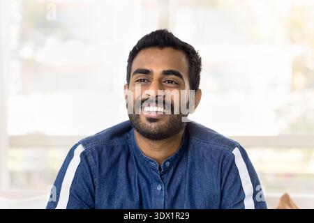 Head shot portrait Indian man laughing, looking into distance Stock Photo