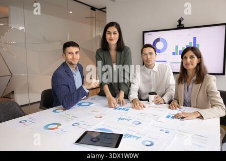 Portrait of confident business professionals gathered around conference table Stock Photo