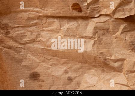 Crumpled paper bread packaging with greasy stains for the topics of food packaging, paper contamination, oil stains, and kraft paper texture Stock Photo