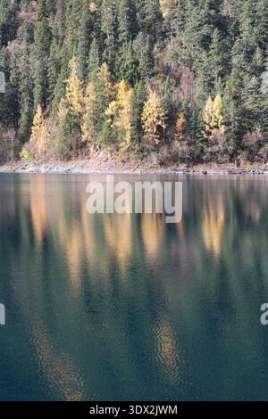 Morning view of crystal-clear emerald Long Lake reflect the colorful forests at the Long Lake of Jiuzhai Valley National Park in autumn, China Stock Photo