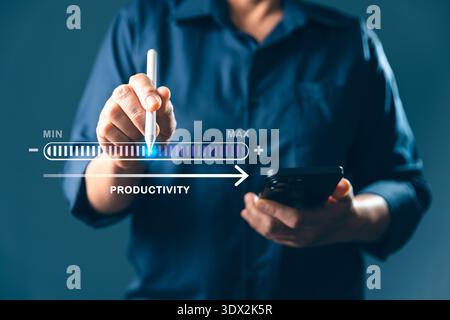 Businessman using stylus on digital productivity slider while holding smartphone, illustrating efficiency boost, performance tracking, time control an Stock Photo