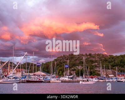 Panoramic view of Hamburgsund harbour, Bohuslän, Sweden, with sailing boats under colorful altocumulus clouds at sunset on Scandinavian west coast Stock Photo