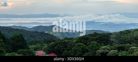 View west from Monteverde resort at sunrise over the hills towards Pacific ocean in broad panoramic format Stock Photo