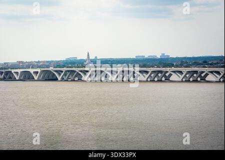 A wide shot captures the Arlington Memorial Bridge gracefully arching over the Potomac River. The Washington Monument rises prominently in the distanc Stock Photo