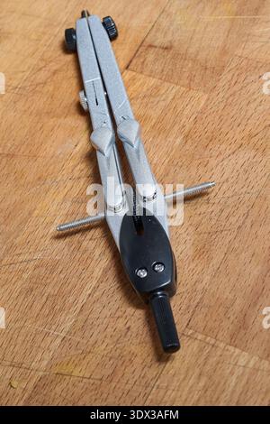 A compass for drawing precise circles on a wooden background Stock Photo