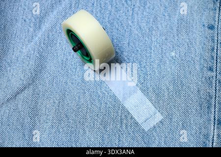 A roll of invisible tape on a denim jeans canvas Stock Photo