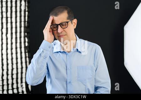 Mature man, discussion and screen with interview for talk and suffering from severe headache, pressing fingers to temples with closed eyes Stock Photo