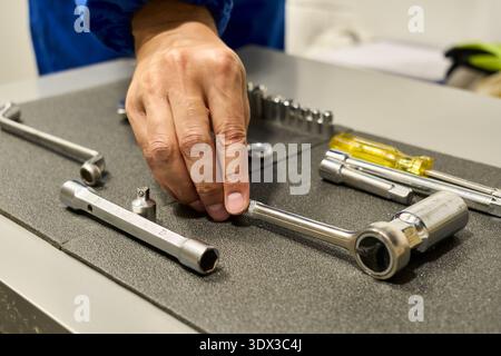 Man's hands grabbing a tool from his tool Stock Photo