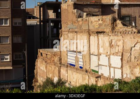 Exposed interior party wall of a demolished historic building showing remnants of decorative ceramic tiles and structural outlines in a Mediterranean Stock Photo