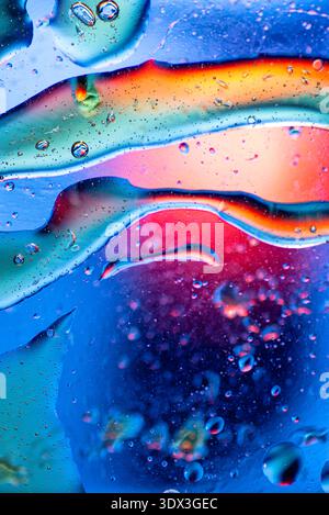 : Colorful abstract wallpaper with a smooth rainbow gradient and delicate oil bubbles reflecting light on water. Stock Photo
