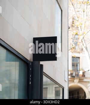 Black rectangular mockup signboard hanging on classic building wall Stock Photo