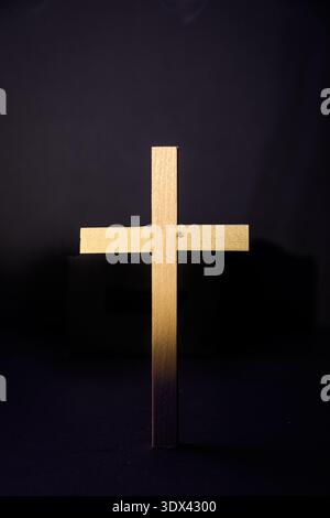 Minimal wooden cross on dark gradient background, Christian symbol for Holy Week, faith, Good Friday and Easter concept, copy space. Stock Photo