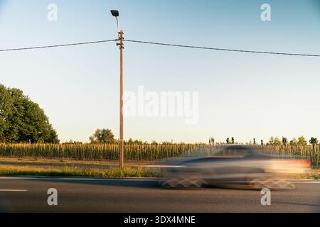 Car Blurs Past Rural Scene Stock Photo