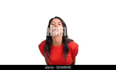 Woman blowing kiss with eyes closed in studio Stock Photo