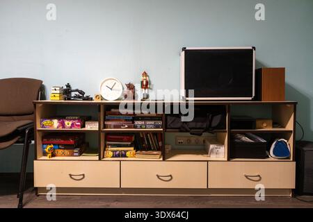 Modern workspace featuring a sleek desk, a comfortable chair, and a large television for productivity and leisure. Stock Photo